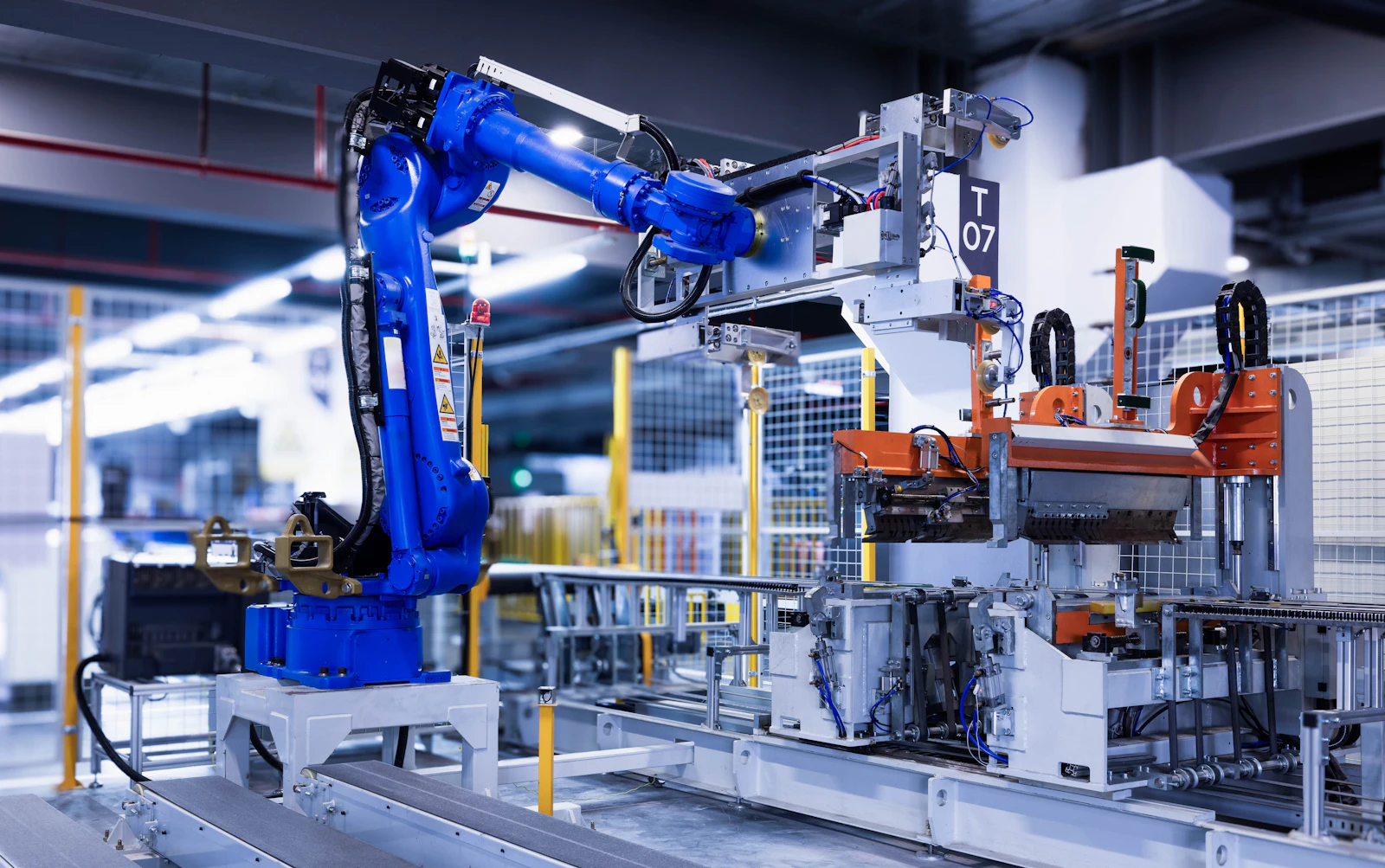 Industrial robotic arm and tooling operating within production equipment